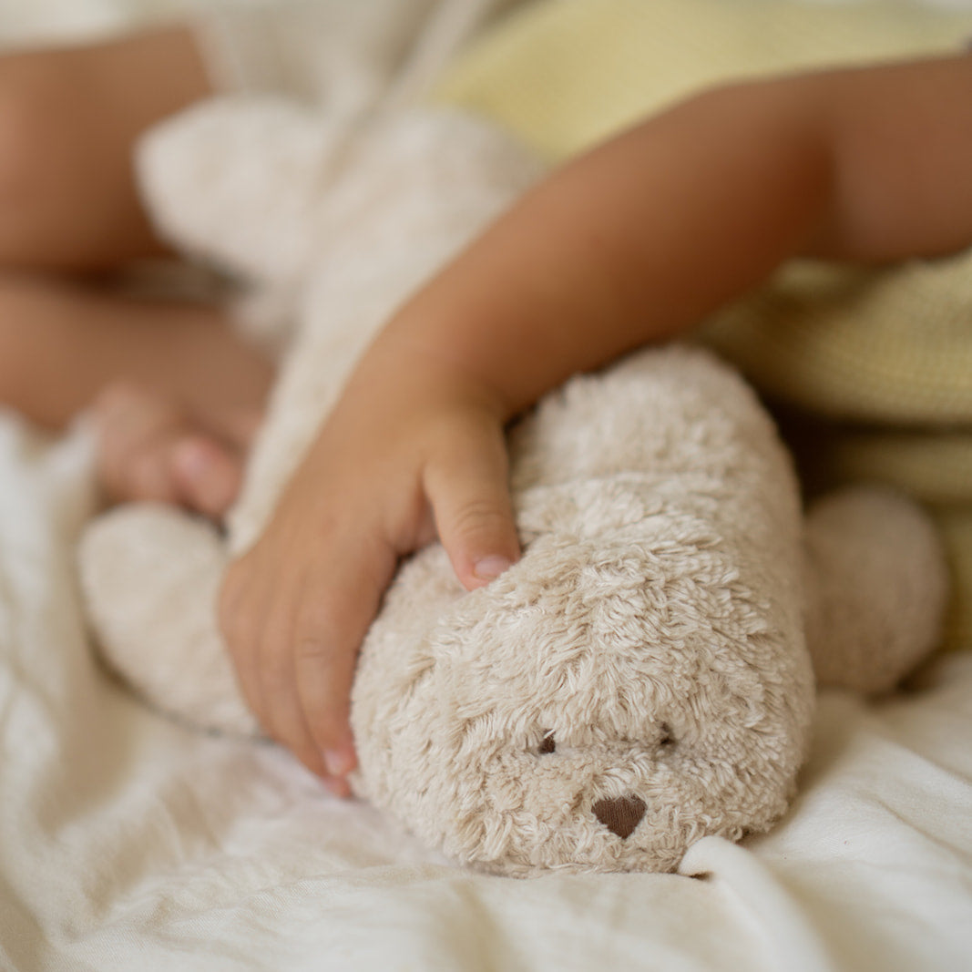 Moonie humming seal sand met arm van kind