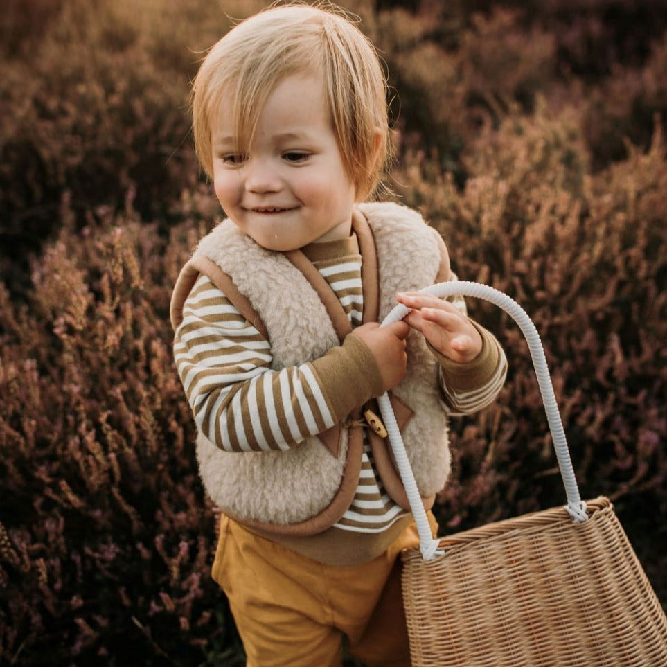 Kind draagt beige wollen bodywarmer van het merk Alwero