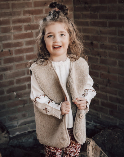 Beige bodywarmer voor kinder(en) van het merk Alwero gemaakt van wol.