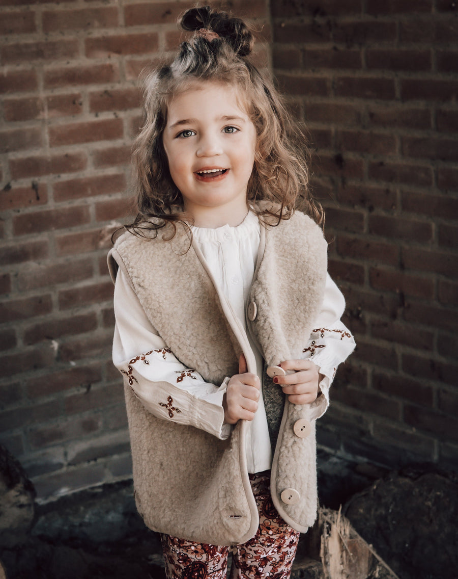 Beige bodywarmer voor kinder(en) van het merk Alwero gemaakt van wol. 