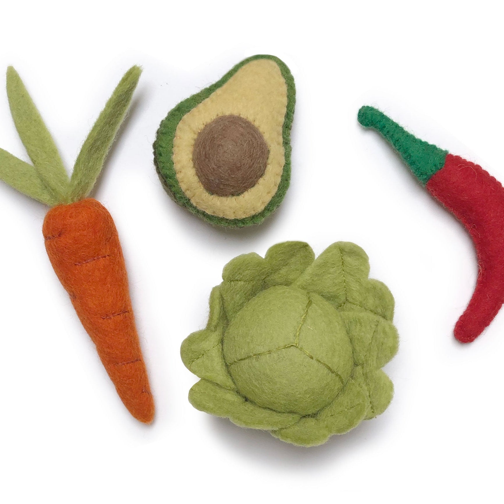 Handgemaakt vilten fruit op een witte achtergrond van gamcha. Een wortel, avocado, spaanse rode peper en slakrob. 