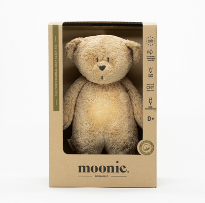 De slaapknuffel van Moonie in de vorm van een beer in de kleur cappuccino voor baby's die rustgevende geluiden maakt die de slaap bevorderen in doos.
