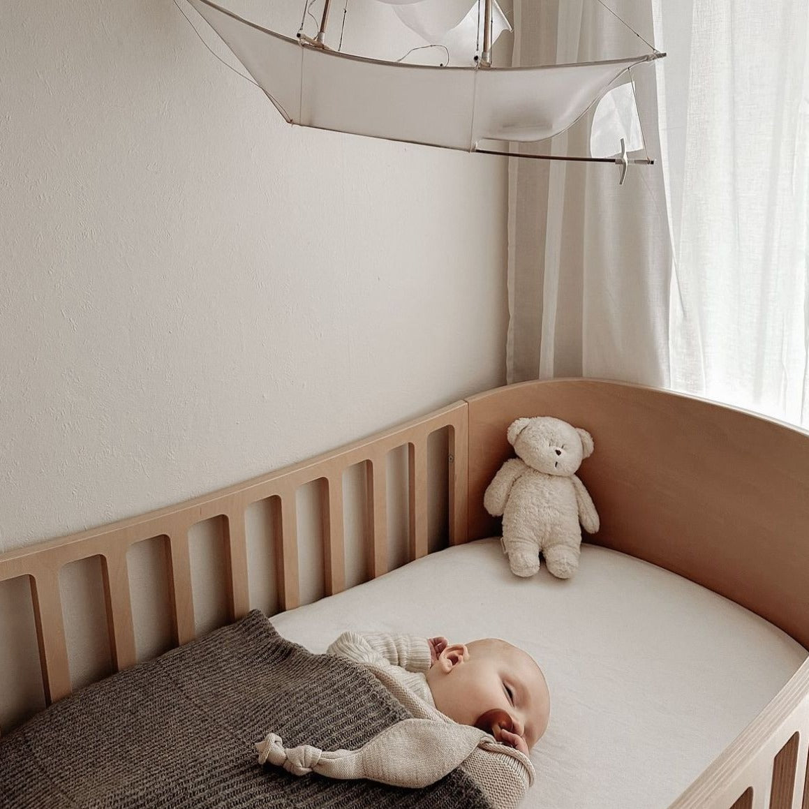 De slaapknuffel van Moonie in de vorm van een sand in de kleur rose voor baby's die rustgevende geluiden maakt die de slaap bevorderen. 