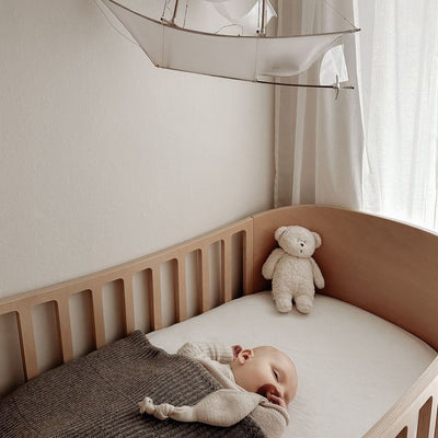 De slaapknuffel van Moonie in de vorm van een sand in de kleur rose voor baby's die rustgevende geluiden maakt die de slaap bevorderen.