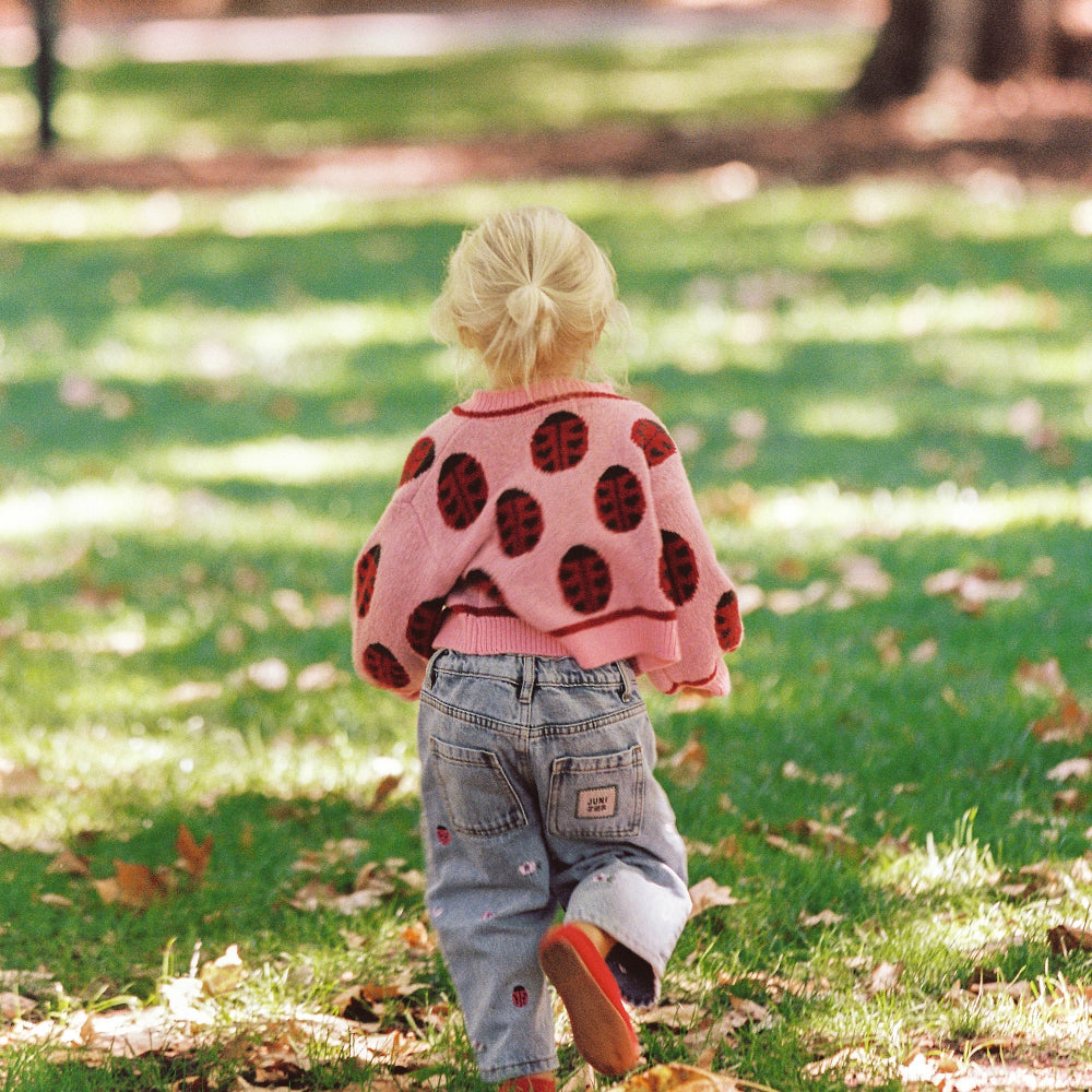 Rose lovebug cardigan van eht merk Juni aan bij meisje achterkant