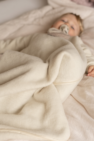 Slaapzak gemaakt van biologische merino wol fleece voor baby's en kinderen van Reiff in het naturel.