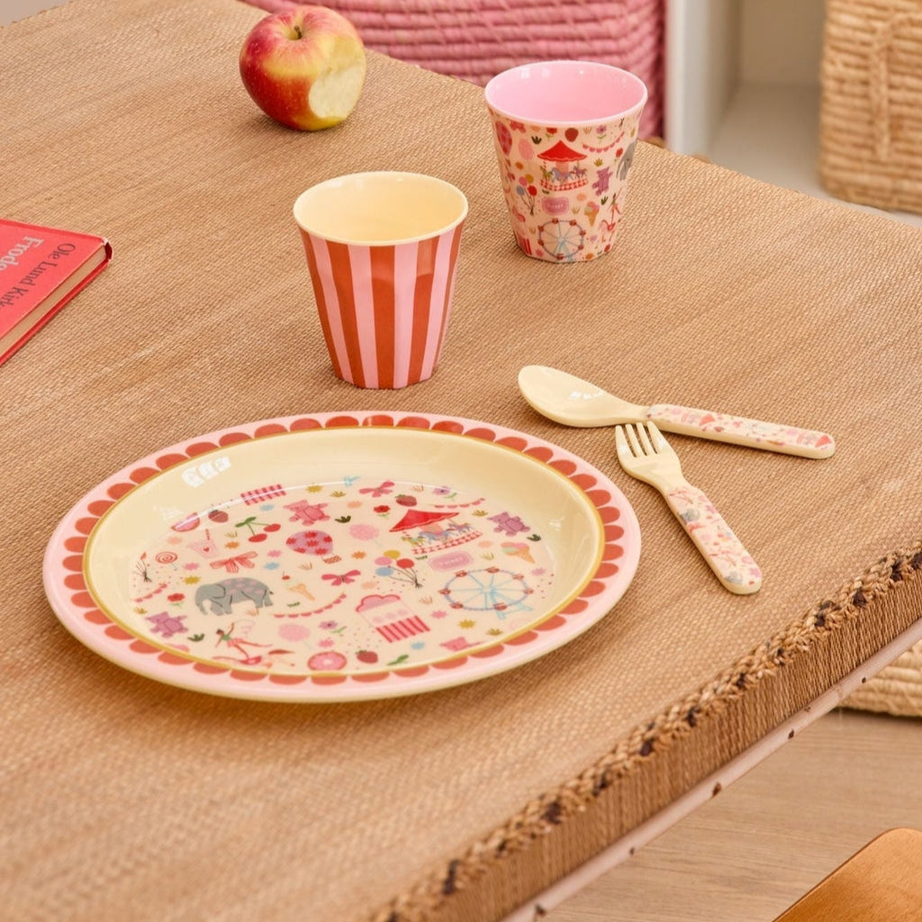 Roze bord voor kinderen met circus figuurtjes erop op tafel