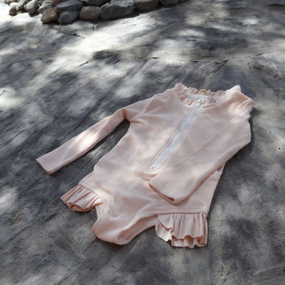 UV zwempak voor kinderen ter bescherming tegen de zon in het rose met lange mouwen..
