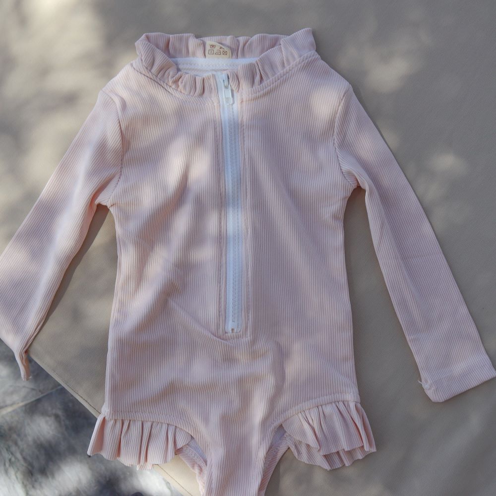 UV zwempak voor kinderen ter bescherming tegen de zon in het rose met lange mouwen.