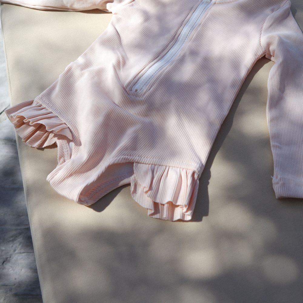 UV zwempak voor kinderen ter bescherming tegen de zon in het rose met lange mouwen..
