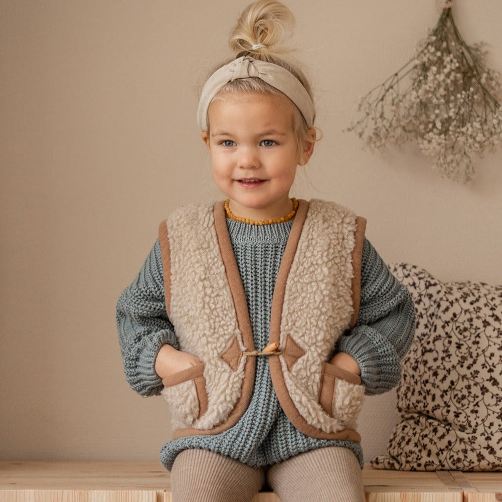 Kind draagt beige wollen bodywarmer van het merk Alwero 