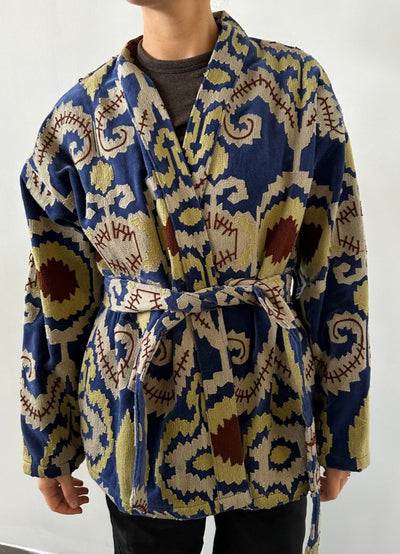 Benola Velvet Suzani Jacket is een zacht jasje dat is geüpcycled van een fluwelen deken. Het jasje is prachtig versierd met kleurrijke Suzani-borduursels all-over. Benola Velvet Suzani Jacket is gemaakt in een kimono-vorm met verlaagde schouders en lange mouwen. In de zijnaden vind je zakken en in de taille een afneembare riem.