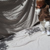 Kind draagt bruine wollen bodywarmer met capuchon van het merk Alwero