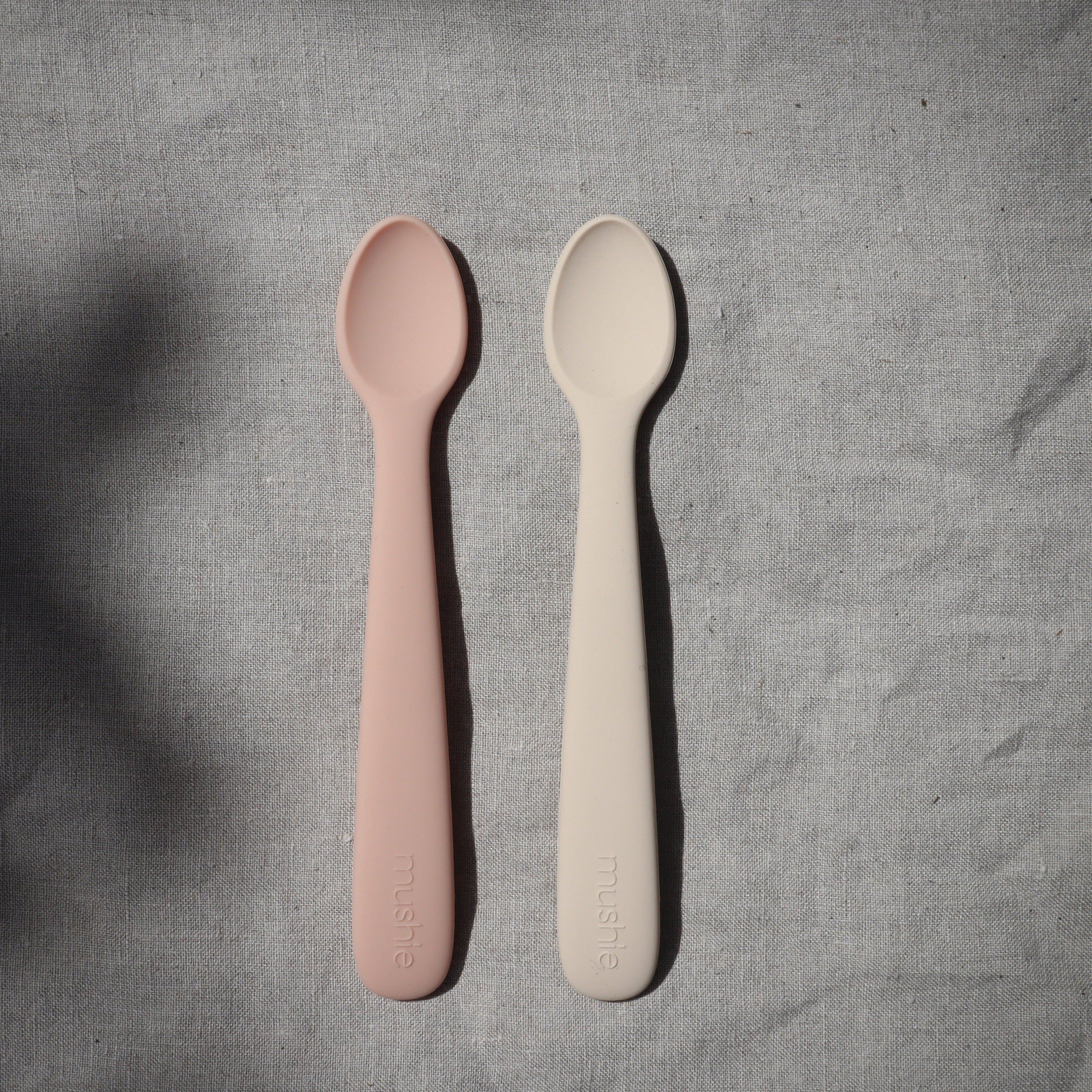 Twee lepels van baby's (kinderen) in het naturel en rose om te eten van Mushie.