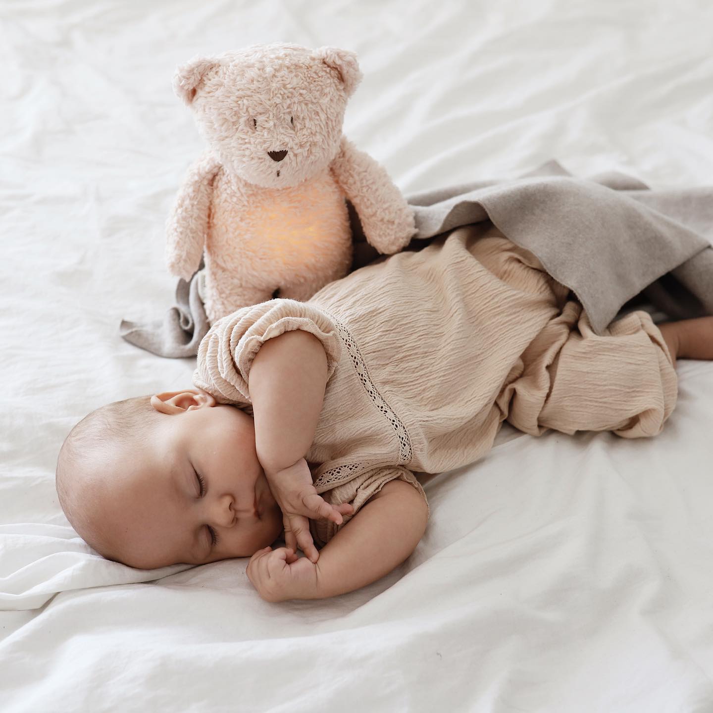 De slaapknuffel van Moonie in de vorm van een beer in de kleur rose voor baby's die rustgevende geluiden maakt die de slaap bevorderen. 