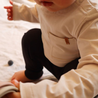 Longsleeve dust voor baby's (kinderen) met een zakje aan de voorzijde van het merk Nixnut.